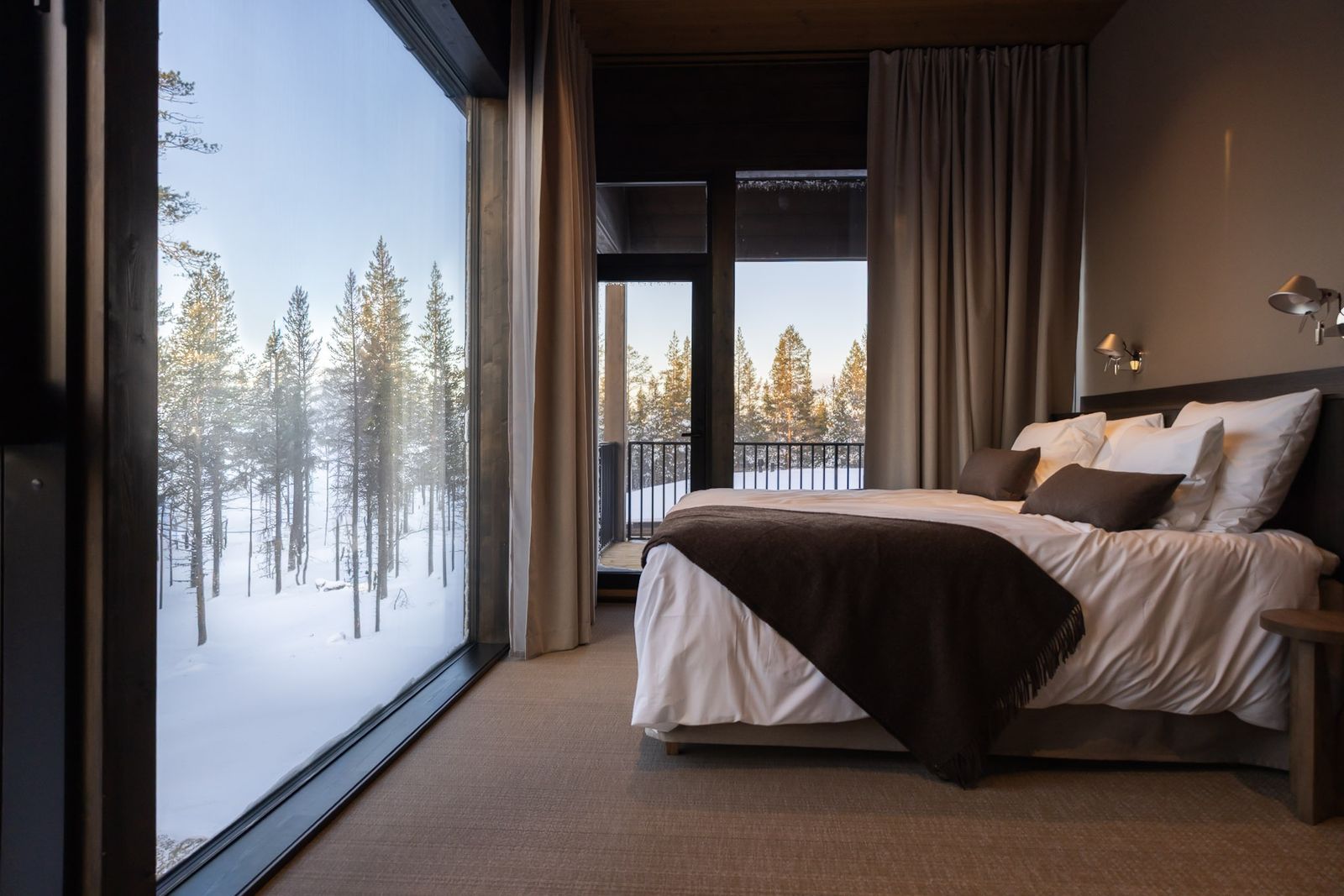 hotel bedroom looking out onto snow and trees