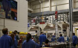 Students participating in the Undergraduate Student Instrument Project observe vibration testing of the payload.