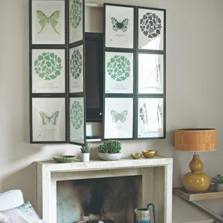 A living room with a TV hung above a fireplace and covered with an artwork