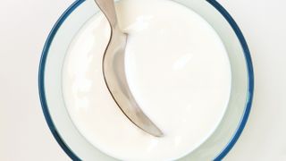 Greek-style yogurt in glass with silver spoon