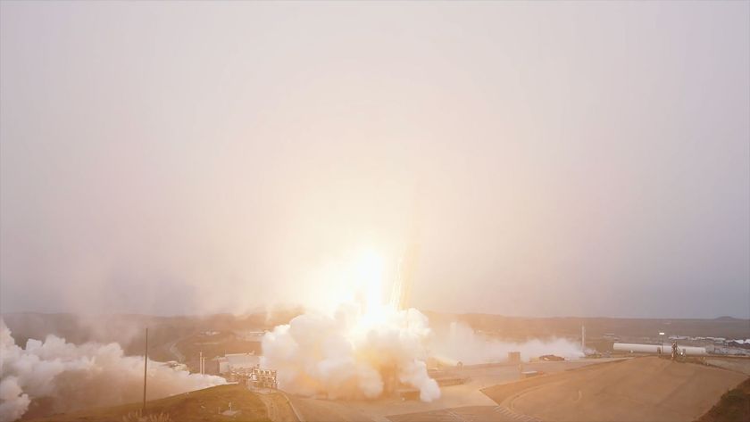 A rocket lifts into a fog layer blanketing its launch site, obscuring the view of the booster.