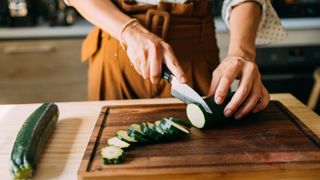 person slicing courgettes