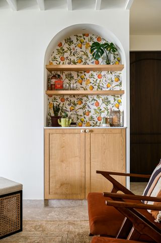 A citrus print lines a home bar in an otherwise neutral room