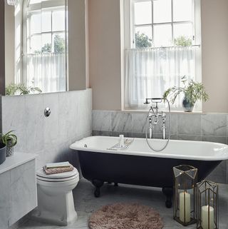 Traditional bathroom with roll top bath and sash window