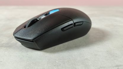 Three-quarter view of Logitech G305 X Superlight on desk with pink wall in background