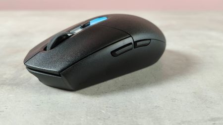 Three-quarter view of Logitech G305 X Superlight on desk with pink wall in background