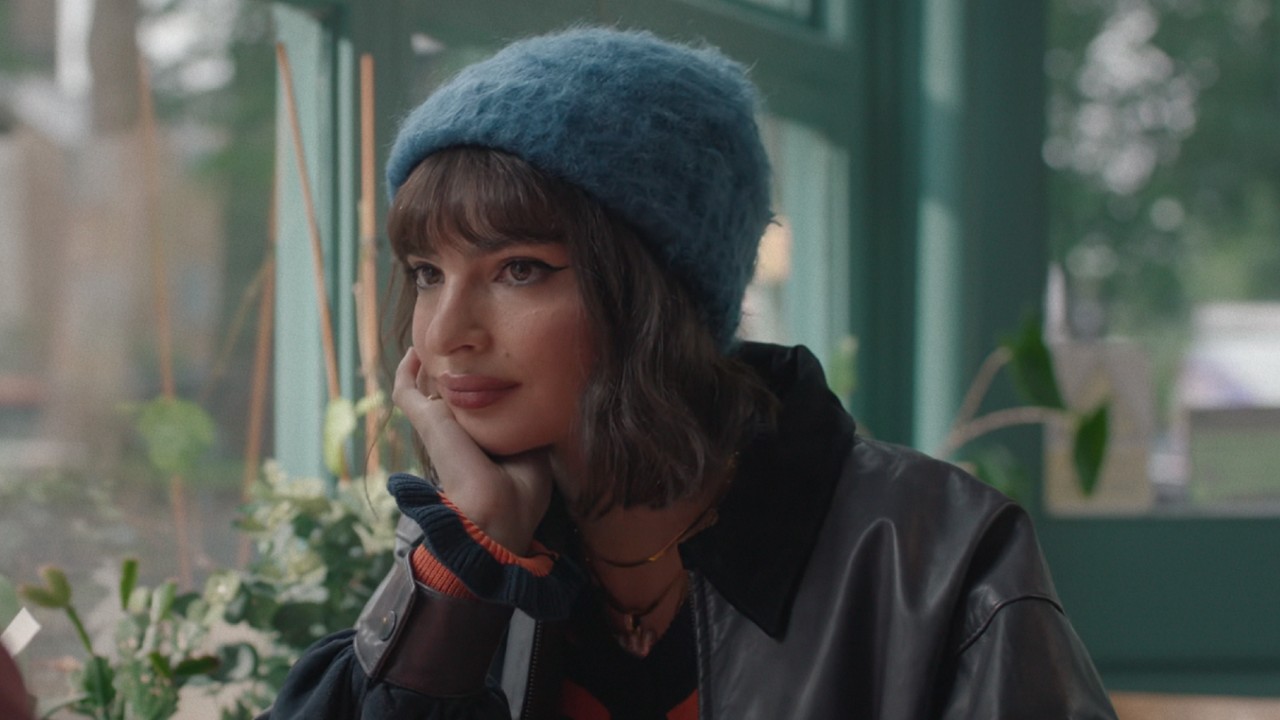 Emily Ratajkowski resting her head on her left hand in Too Much.