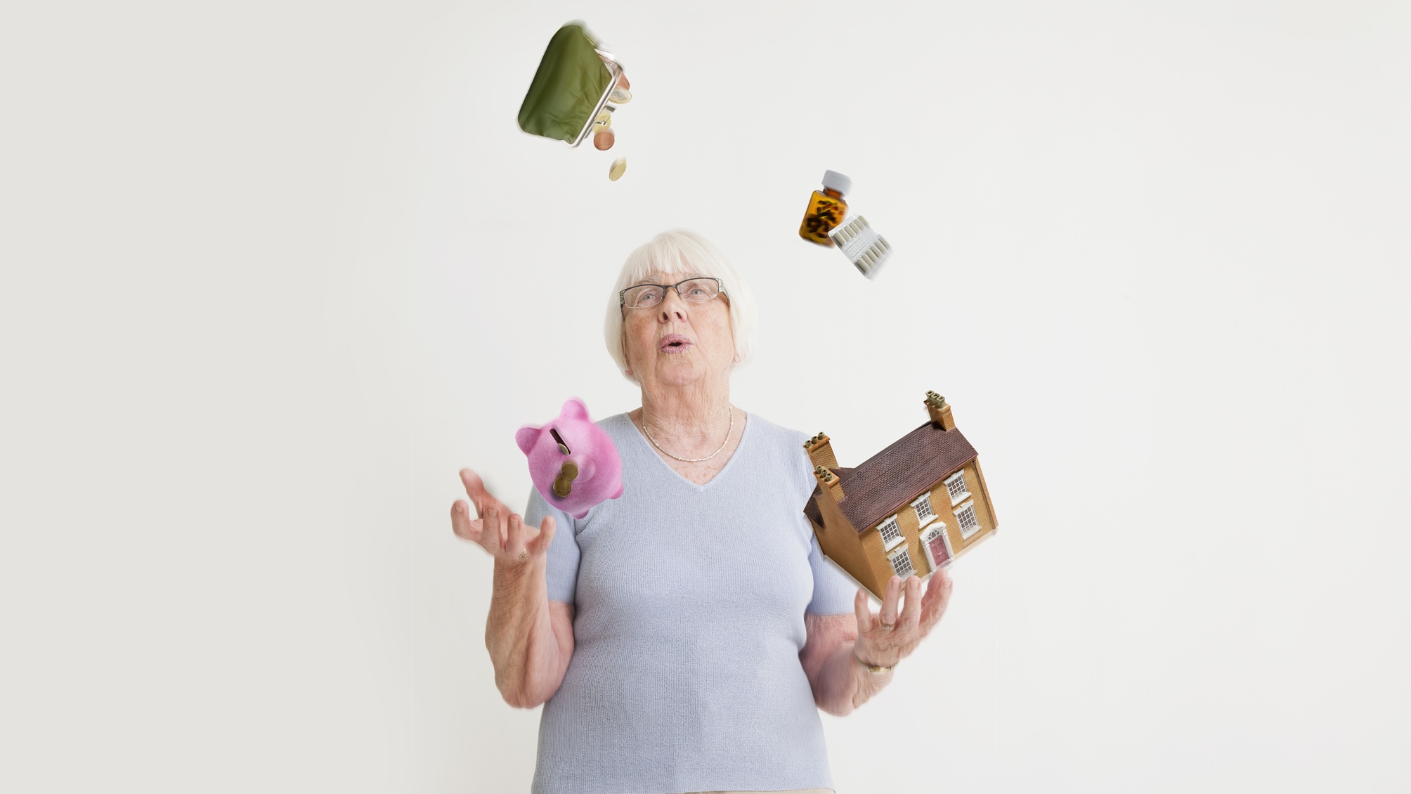An older woman juggles items representing expenses, such as a piggy bank and a pill bottle.