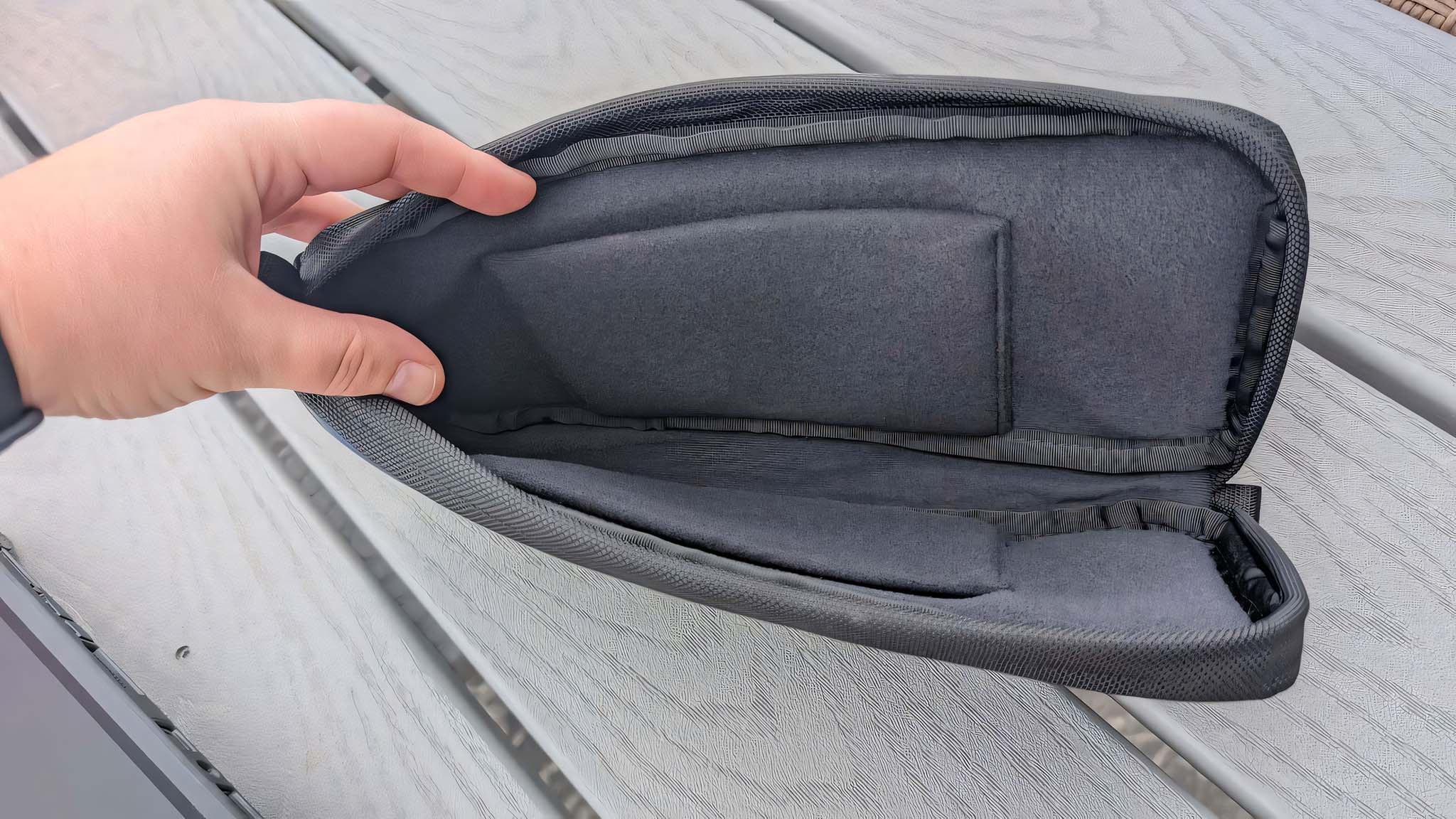 A hand holding the Waterfield ROG Ally X Magnetic Case open to view the inner pockets.