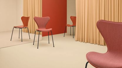 Red chairs in a room with glass mirror and peach curtains 