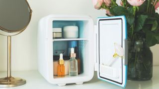 Mini fridge on the vanity table. Selfcare concept. Keep skincare, makeup and beauty product cool and fresh. Extend shelf live of creams, serums. Keep your beauty products organized and cool.