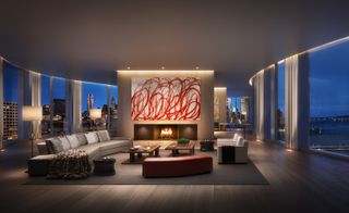 The interior of a full floor penthouse in the building featuring glass walls, furnitures and a fire place with abstract art above.