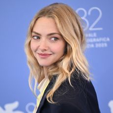 Amanda Seyfried looks over her shoulder wearing a blazer