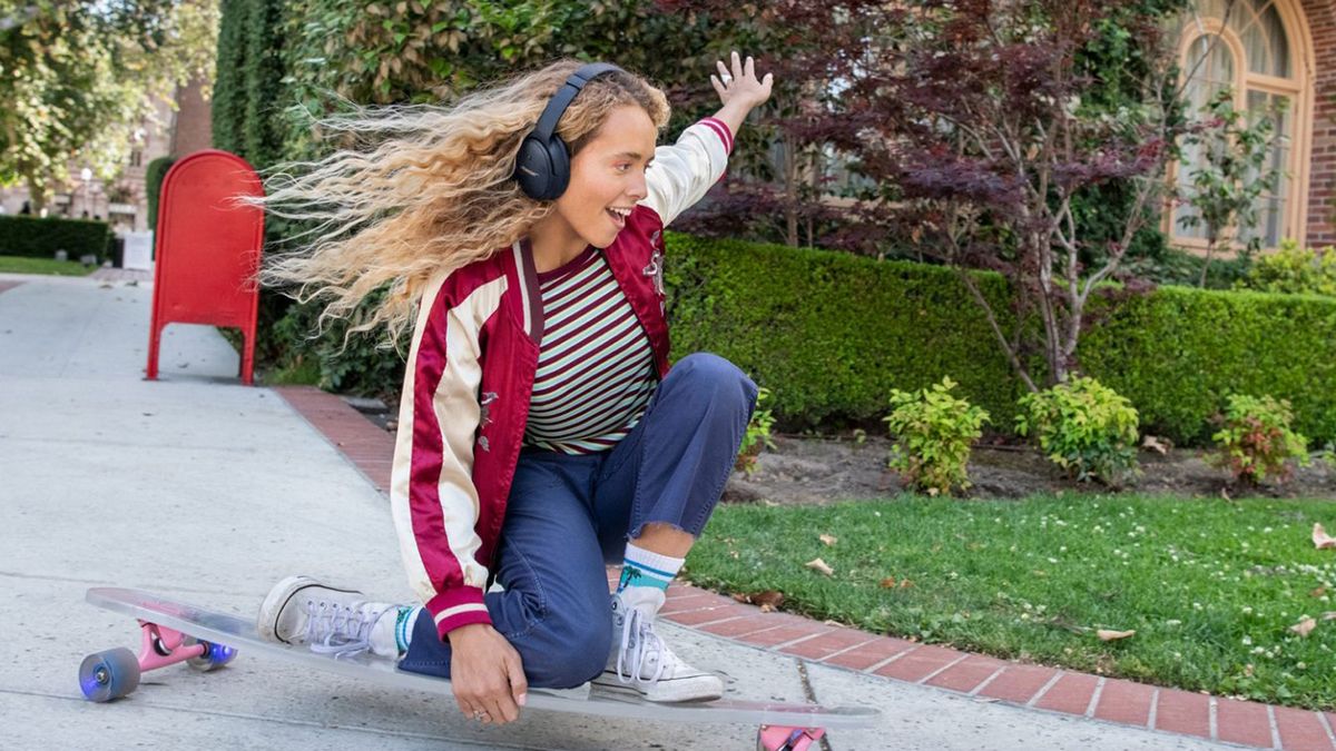 Girl wearing Bose QC 45 headphones while skateboarding