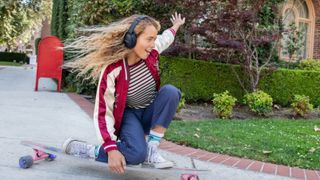 Girl wearing Bose QC 45 headphones while skateboarding