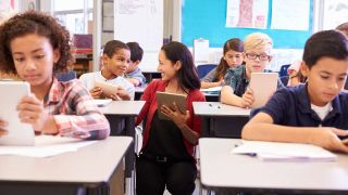 Teacher and kids in classroom with tablet computers