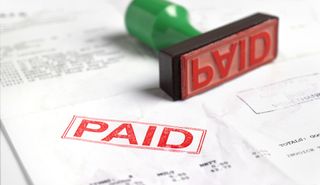 An invoice stamped with the word 'paid' - how to pay off debts fast