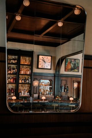 Clock behind bar, seen reflected in mirror at Locanda Verde Hudson Yards