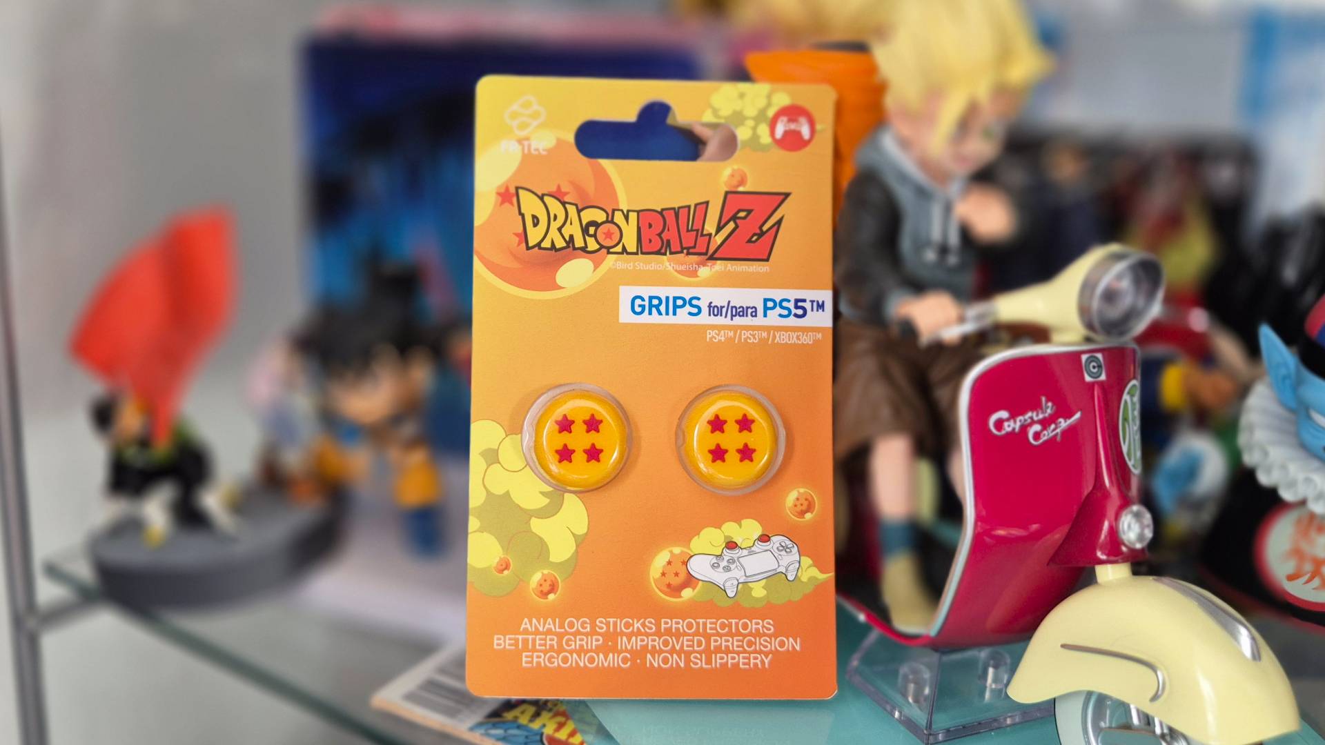 Photo by Rosalie Newcombe of the DBZ Thumb Grips by FRTEC sitting in a cabinet full of Dragon Ball figures.