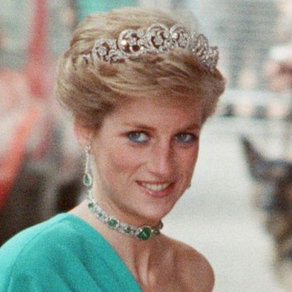 Princess Diana wears a one-shoulder green gown with a sparkling tiara
