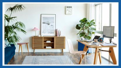 Computer at table in apartment. Bright modern room with furniture. Interior of home office.