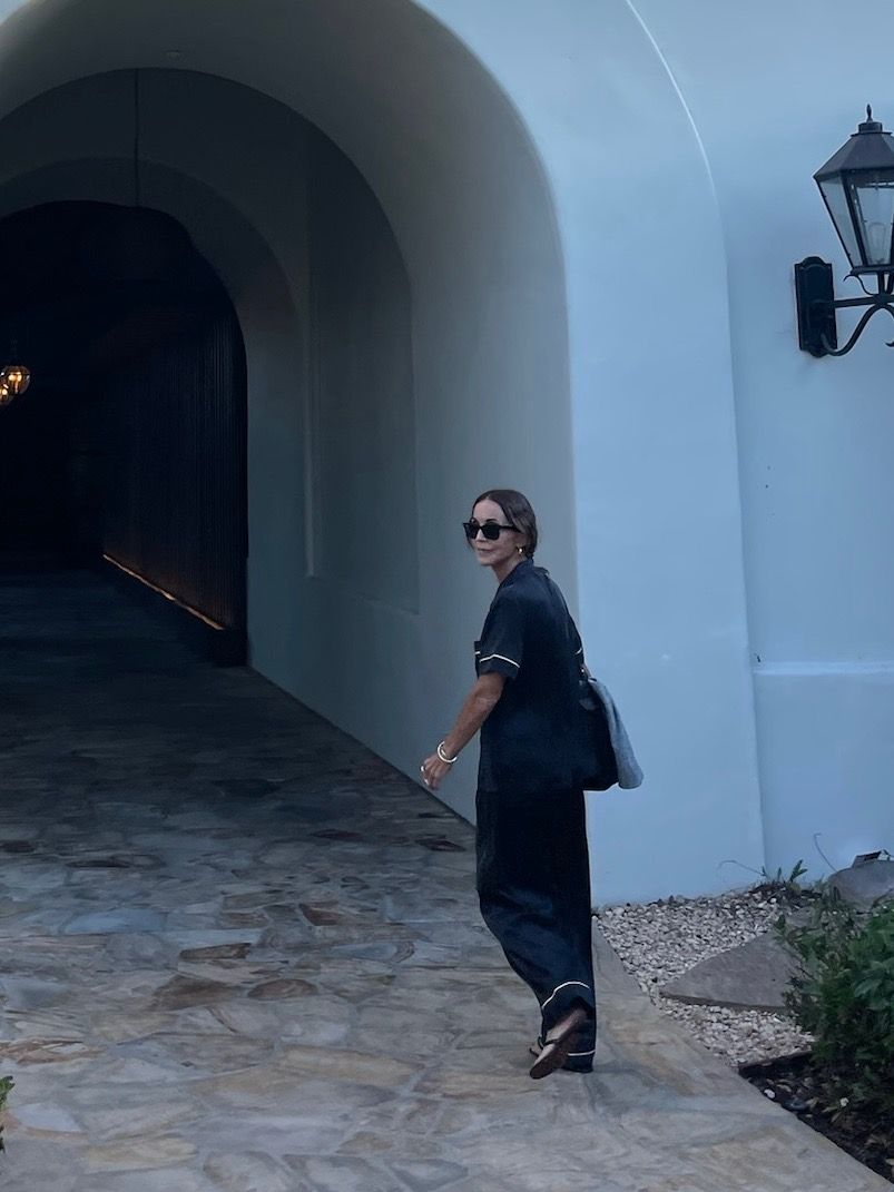 Larissa Mills wearing black silk pajamas outside