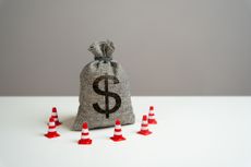 Dollar money bag blocked by road cones. Freezing of accounts and sanctions on capital. Dedollarisation. Suspicious funds with unknown sources. National money reserve.