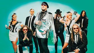 The Night Flight Orchestra all glammed-up in stage clothes and photographed against a green backdrop: guitarists Rasmus Ehrnborn [second from left] and Sebastian Forslund [fourth from right]