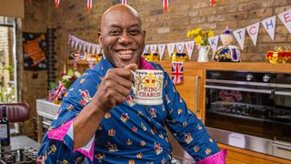 Ainsley Harriott poses with a King Charles mug for Ainsley's Coronation Kitchen