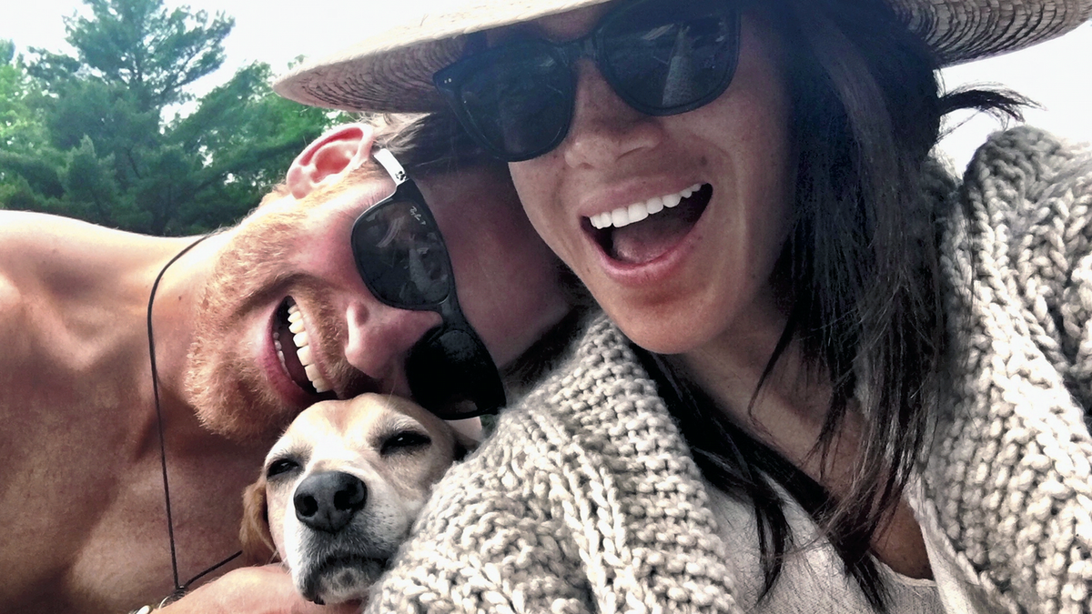 (L to R) Prince Harry, Guy the dog and Meghan Markle pose for a photo with one of their dogs in Harry &amp; Meghan