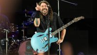 Dave Grohl performing with a blue guitar