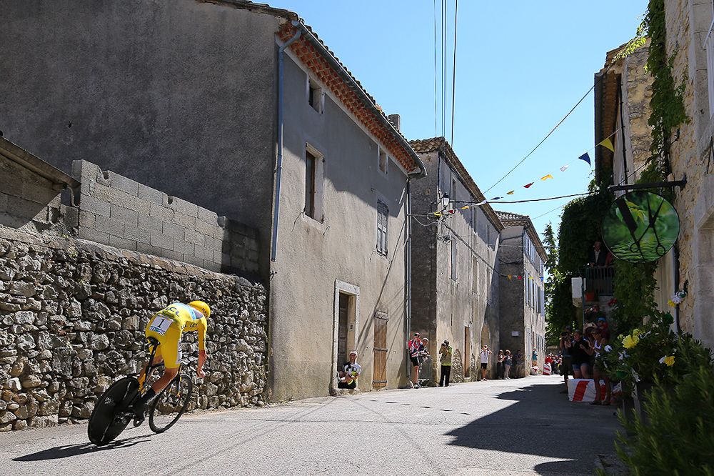 Chris Froome rides through a French village during stage 13