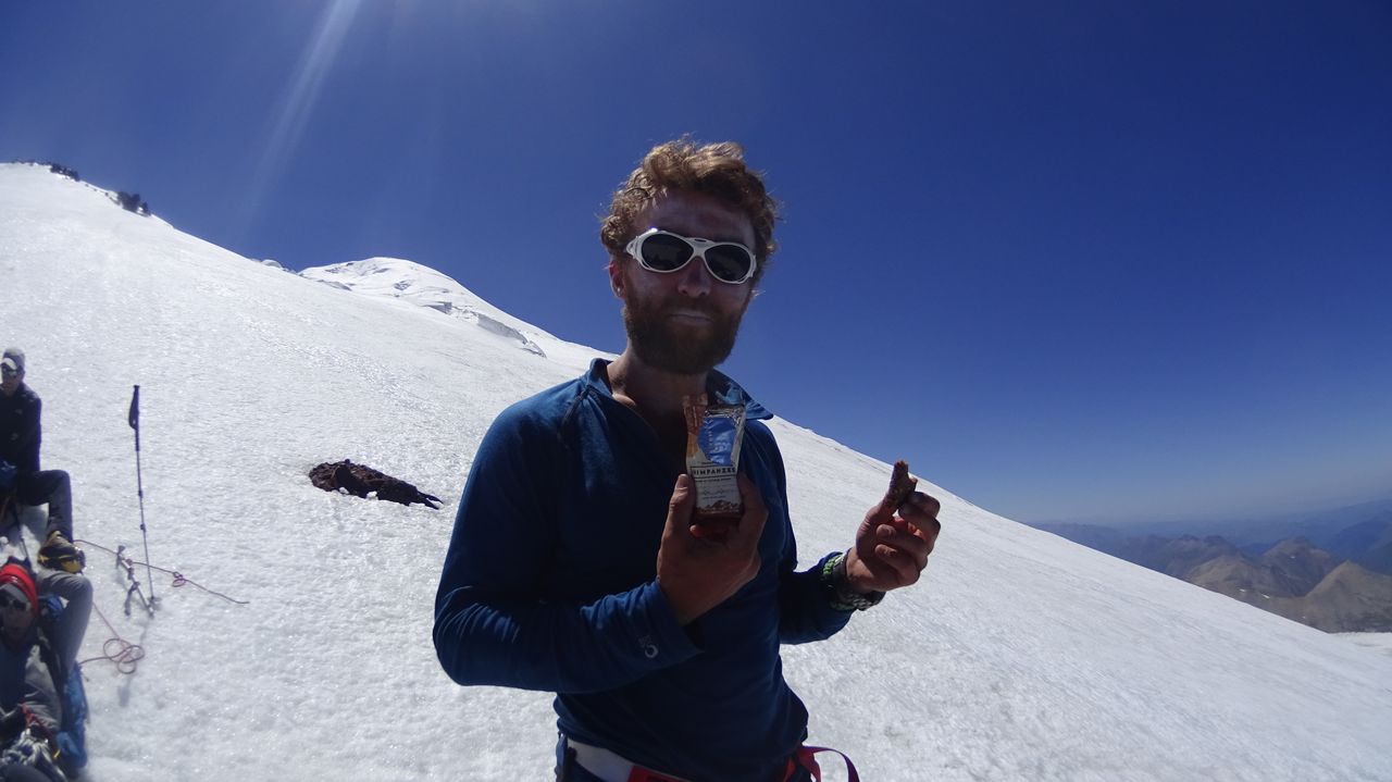 Men eating cake on top of a Russian mountain