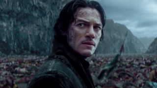 Luke Evans stands with concern amid a field of dead bodies in Dracula Untold.