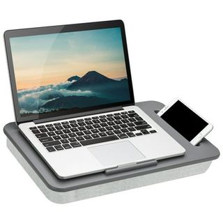 A grey laptop knee trap with a lip to stop a laptop slipping, and a indent to hold a phone