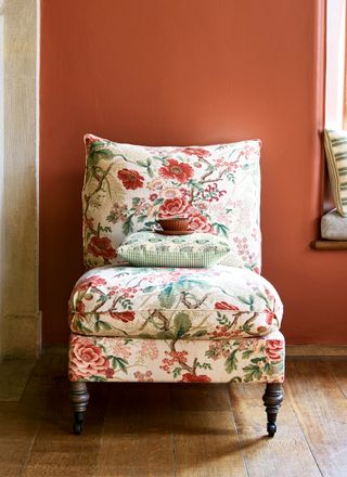 Terracotta living room and chair in Tree Poppy fabric by Colefax & Fowler