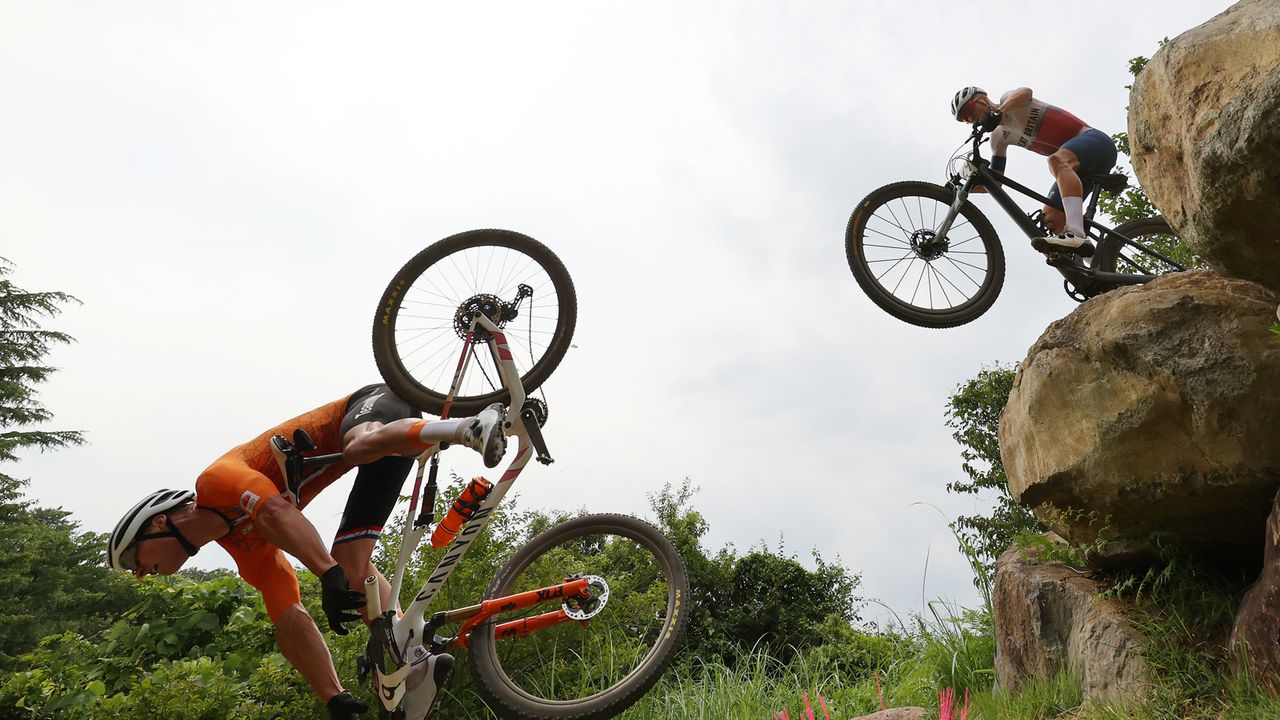 Mathieu van der Poel of Team Netherlands suffers a fall ahead of Thomas Pidcock of Team Great Britain during the Men's Cross-country race on day three of the Tokyo 2020 Olympic Games at Izu Mountain Bike Course