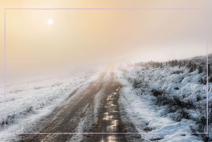 a countryside landscape with freezing fog and the sun on the horizon