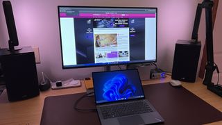 BenQ PD2725U on a desk behind a laptop