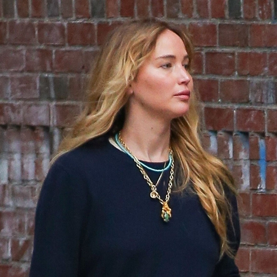 Jennifer Lawrence wearing a black sweater, sheer pants, and black pointed-toe flats 