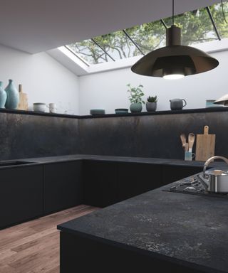 contemporary all black scheme with black cabintery, countertops and backsplash, with white walls, blue grey accessories, hardwood floor, skylight, black pendant light,