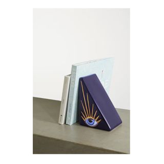 purple triangular bookend with evil eye