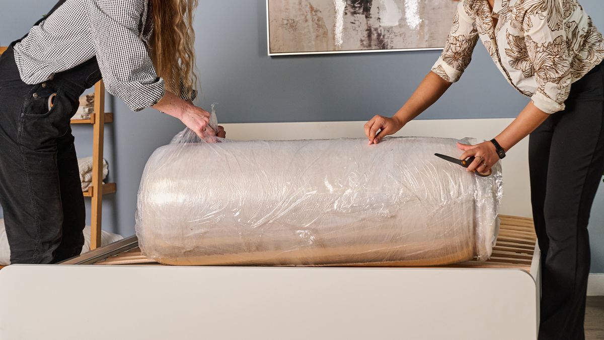 Two Tom's Guide testers taking the plastic off the Birch Luxe Natural as they unbox it