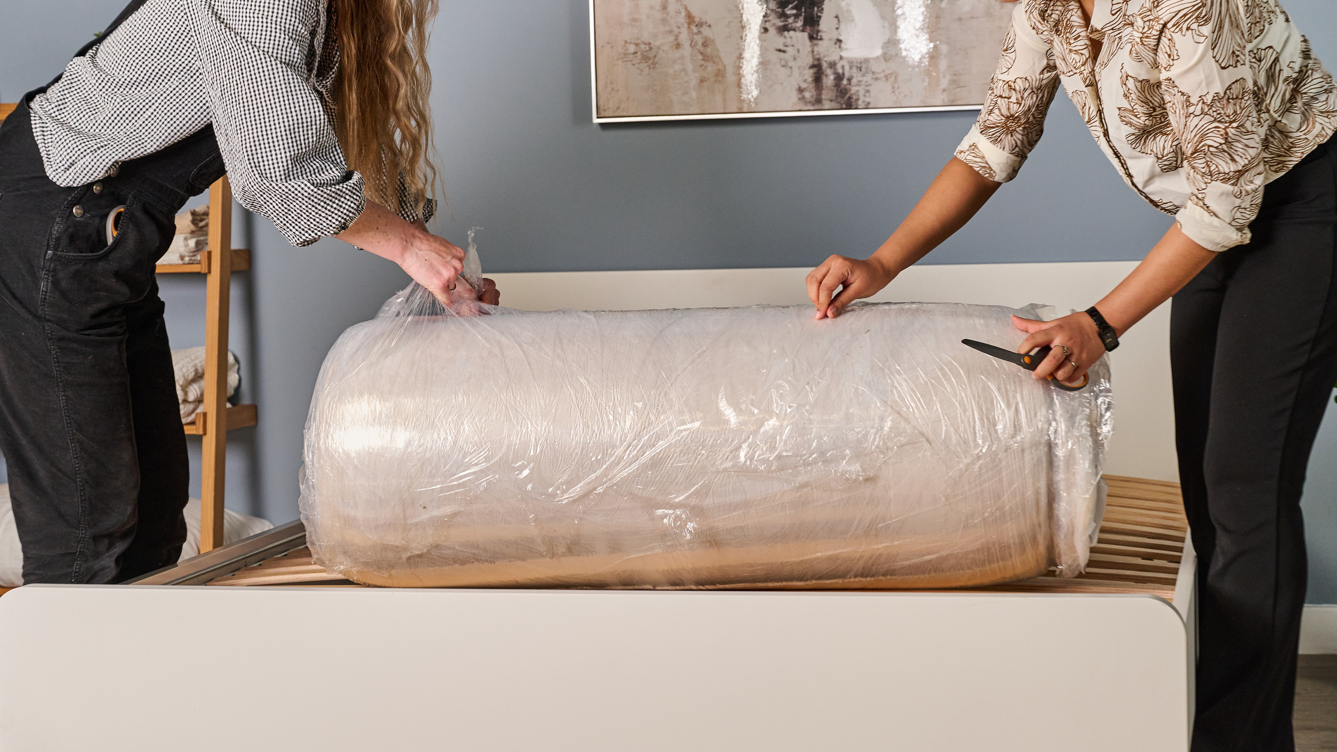 Two Tom's Guide testers taking the plastic off the Birch Luxe Natural as they unbox it