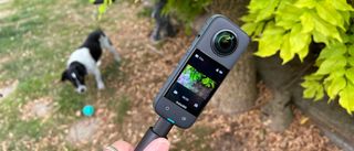 Insta360 X3 being used to film a dog in the garden