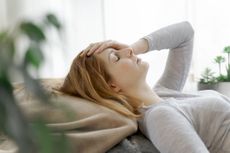 Long Covid symptoms: A woman lies on the bed looking fatigued