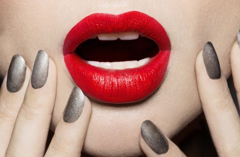 Close up woman with bright red lipstick and silver nails