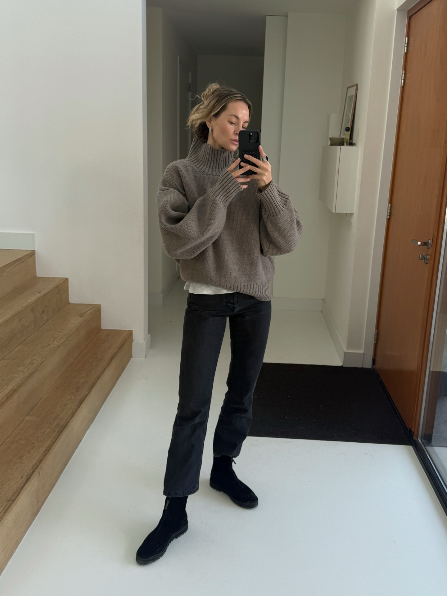 Influencer wearing jeans, a sweater, and boots