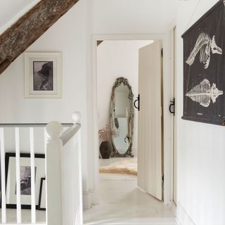 White landing hallway with stairs and wooden beam