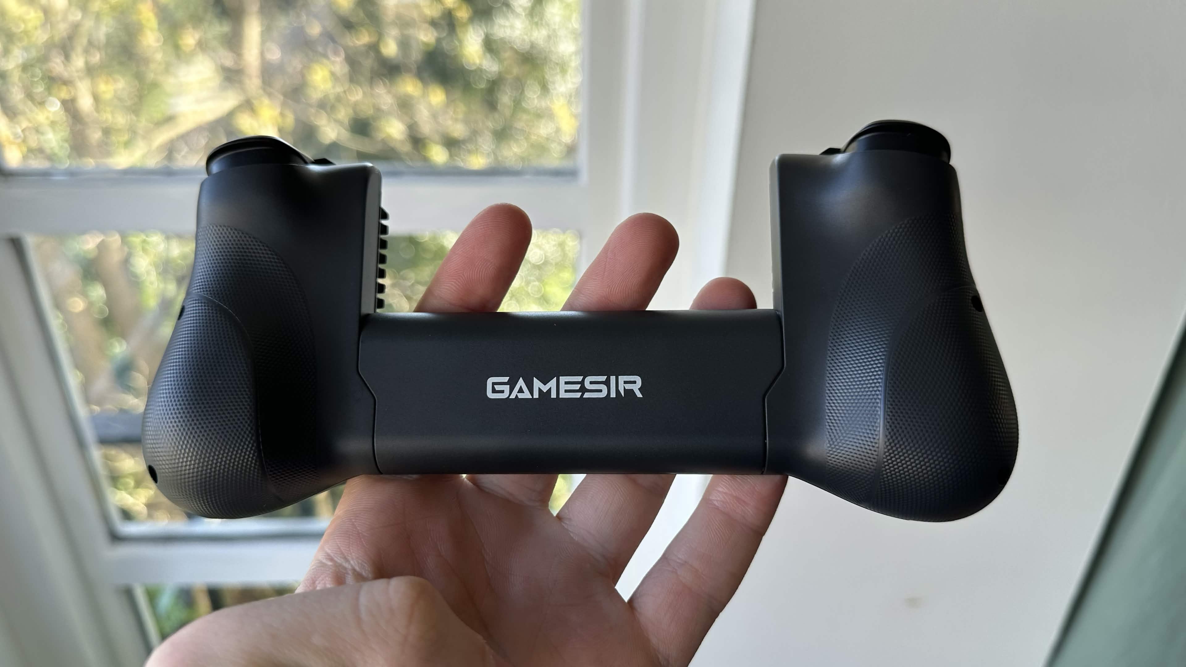 A reviewer showing the back of the GameSir X5s